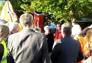 Staatssekretärin Nestle (MELUR) im roten Anorak besucht anti-Fracking-Demonstranten vor ihrer Tür 